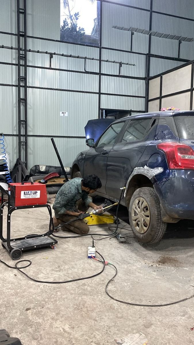 Denting and painting work in progress on a car at Thenath Motors
