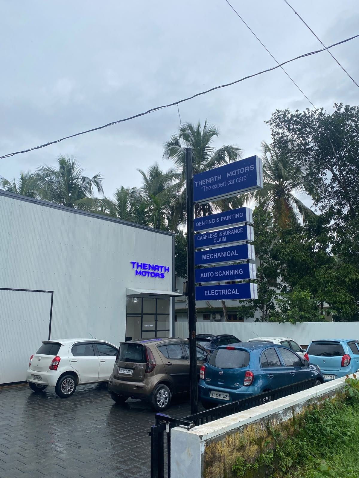Thenath Motors signboard listing denting, painting, mechanical, auto scanning and electrical services